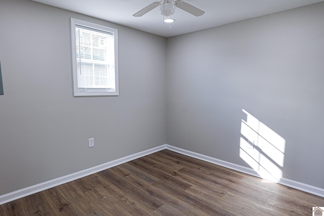 empty room featuring ceiling fan, dark wood-style floors, and baseboards