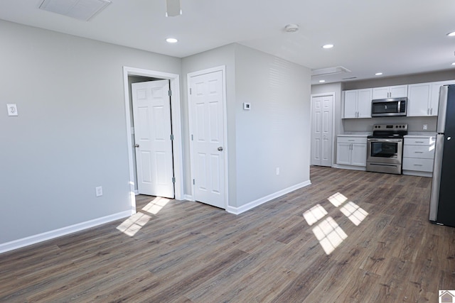 kitchen with white cabinets, appliances with stainless steel finishes, visible vents, baseboards, and dark wood-type flooring