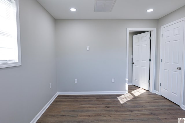 empty room with visible vents, recessed lighting, and dark wood-style floors
