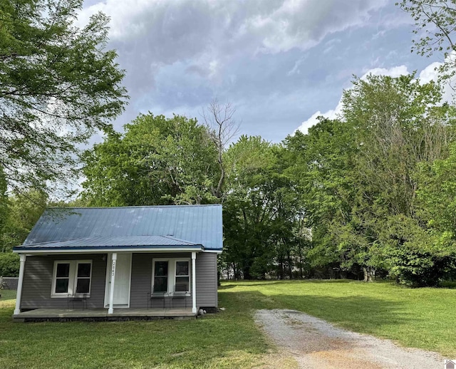 view of outdoor structure featuring a porch and driveway