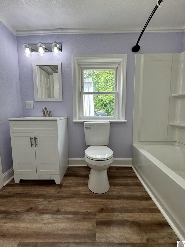 bathroom with wood finished floors, ornamental molding, toilet, vanity, and baseboards