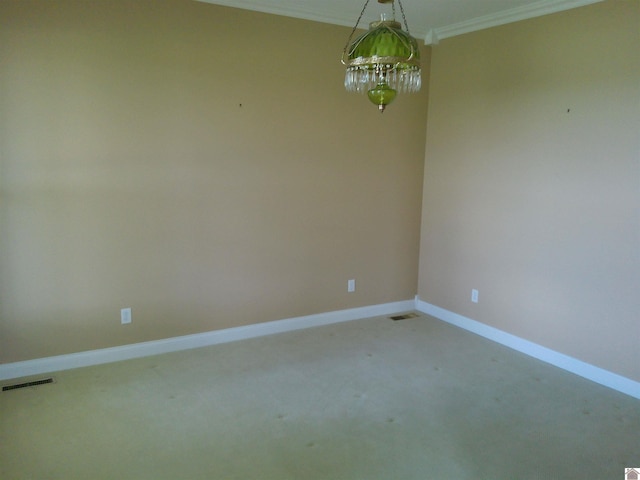 spare room featuring visible vents, baseboards, ornamental molding, and light carpet