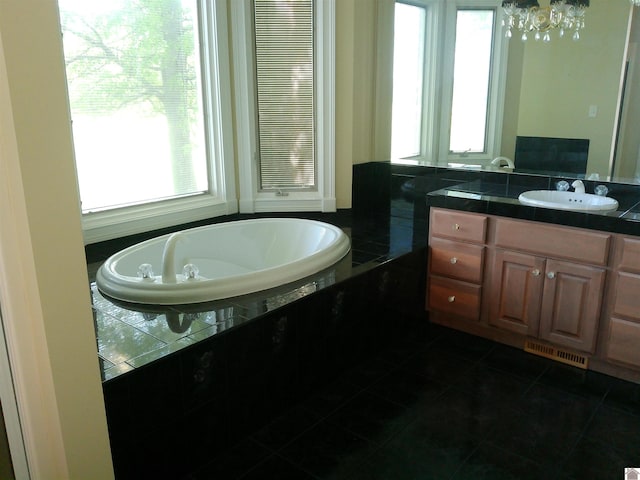 bathroom featuring visible vents, a garden tub, vanity, a notable chandelier, and tile patterned flooring