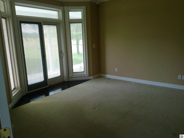 carpeted spare room featuring baseboards