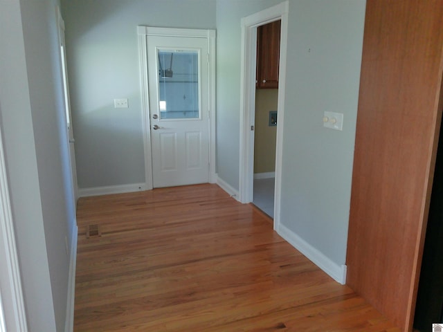 hallway featuring baseboards and light wood-style floors