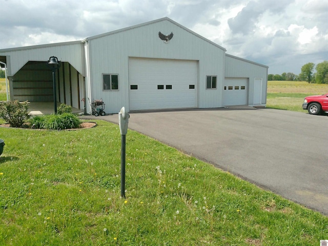exterior space featuring a lawn, an outbuilding, and a garage