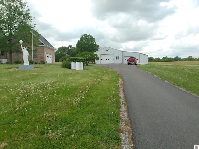 view of front of home featuring an outbuilding, a front lawn, and a garage