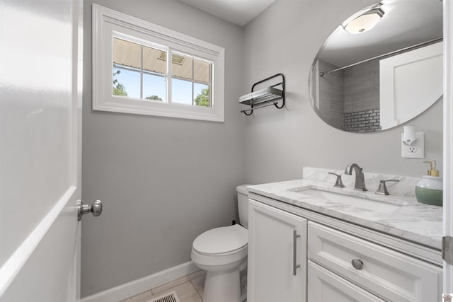 bathroom with vanity, toilet, a shower, baseboards, and tile patterned flooring