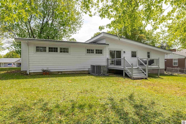 back of house featuring fence, a wooden deck, central AC unit, and a yard