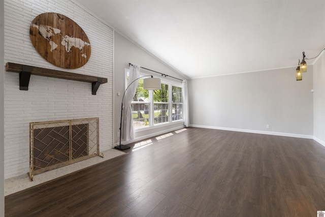 unfurnished living room featuring a brick fireplace, vaulted ceiling, wood finished floors, and baseboards