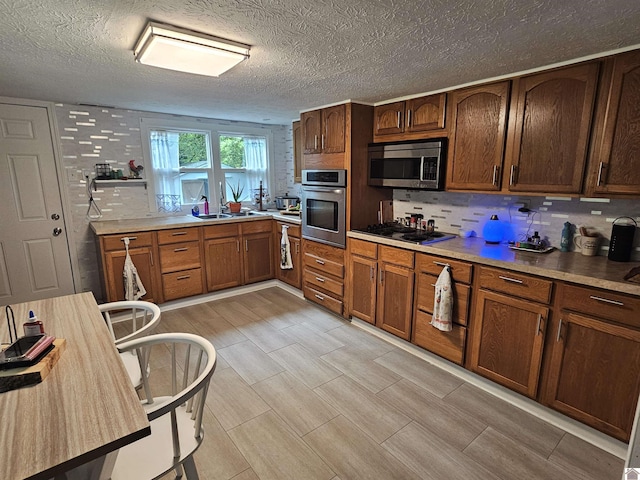 kitchen featuring appliances with stainless steel finishes, decorative backsplash, brown cabinets, and light countertops
