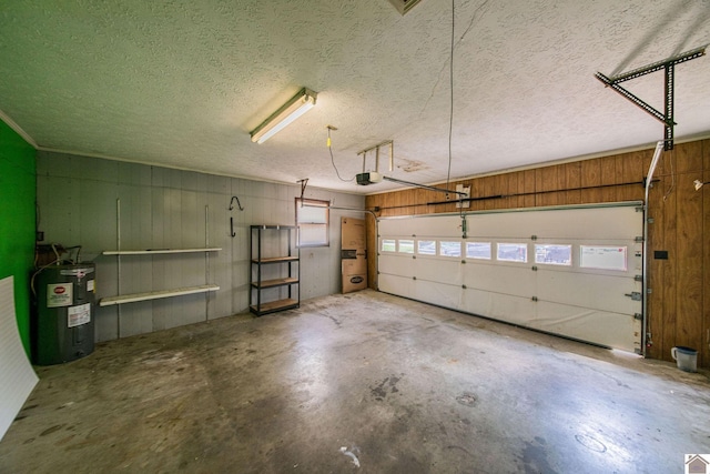 garage with wood walls, a garage door opener, and electric water heater