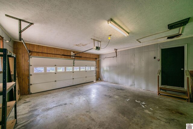 garage with a garage door opener and wooden walls