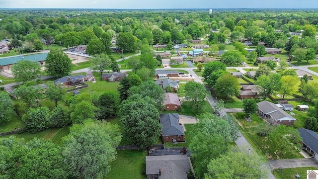 drone / aerial view featuring a wooded view and a residential view