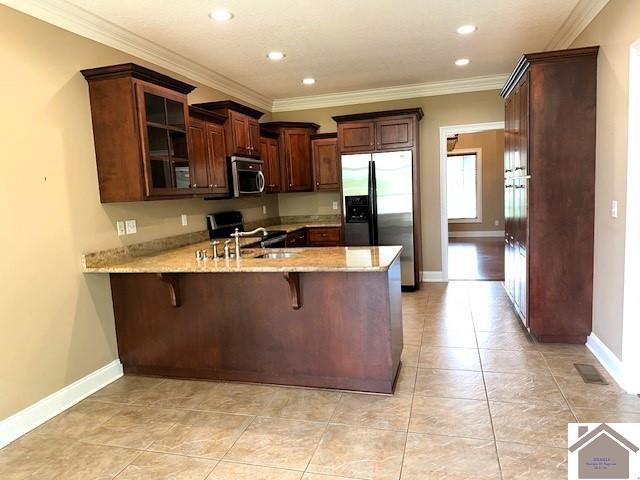57 Rippling Creek Dr, Murray, KY 42071 - kitchen with light stone countertops, a sink, stainless steel appliances, glass insert cabinets, and a peninsula