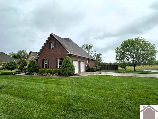57 Rippling Creek Dr, Murray, KY 42071 - view of side of property featuring driveway, a yard, brick siding, and an attached garage