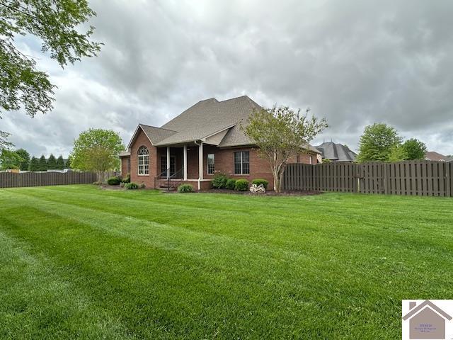 57 Rippling Creek Dr, Murray, KY 42071 - rear view of house with brick siding, fence, and a lawn