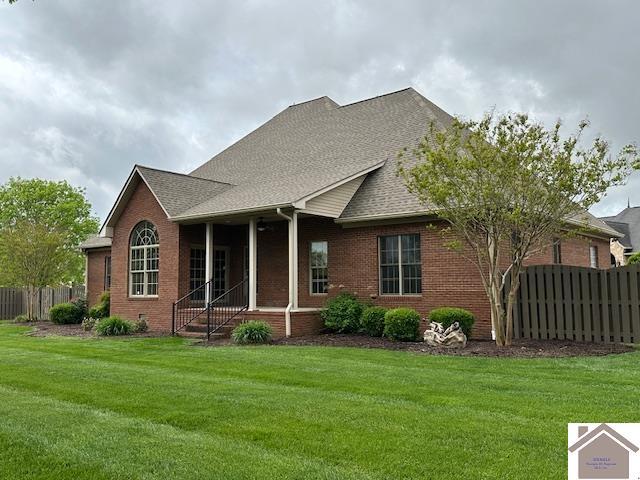 57 Rippling Creek Dr, Murray, KY 42071 - rear view of property with brick siding, fence, and a lawn