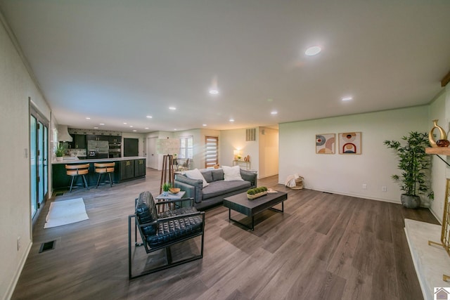 living area featuring baseboards, recessed lighting, wood finished floors, and visible vents