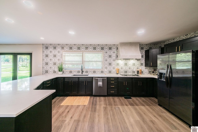kitchen featuring custom exhaust hood, fridge with ice dispenser, dishwasher, a sink, and a peninsula