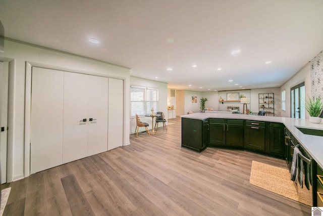 kitchen with recessed lighting, light wood finished floors, light countertops, and green cabinets