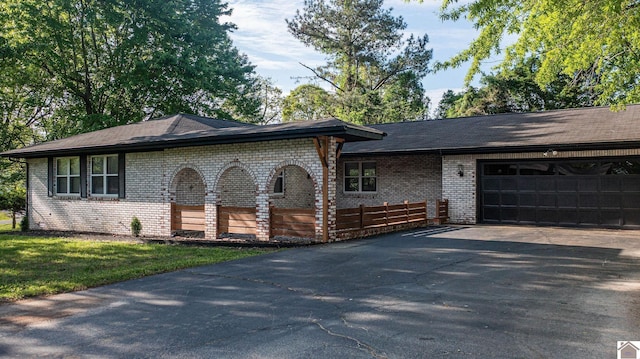 view of front of property with a garage, brick siding, and driveway