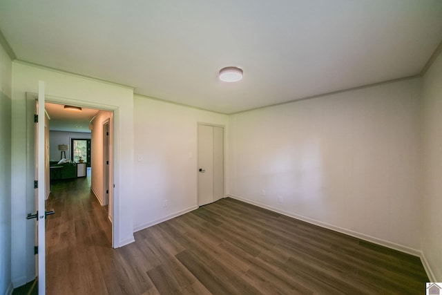 unfurnished bedroom featuring baseboards and dark wood finished floors