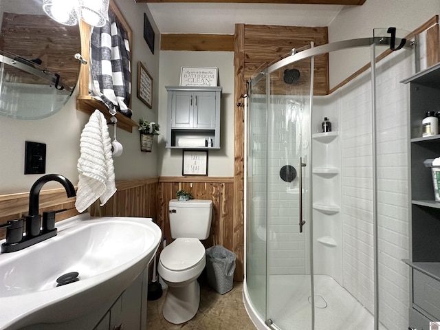 full bathroom with toilet, vanity, a shower stall, and wainscoting