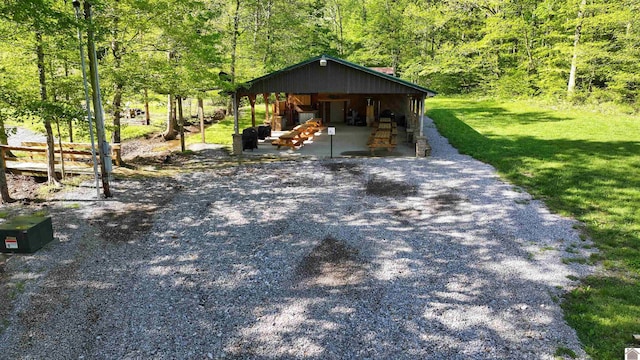 exterior space featuring gravel driveway and a forest view