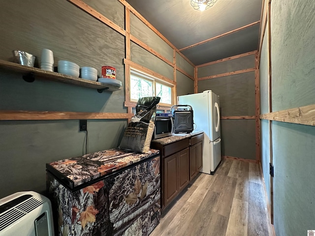 laundry room featuring heating unit, laundry area, and light wood-style flooring