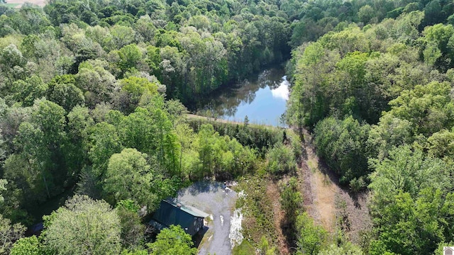 drone / aerial view featuring a wooded view and a water view