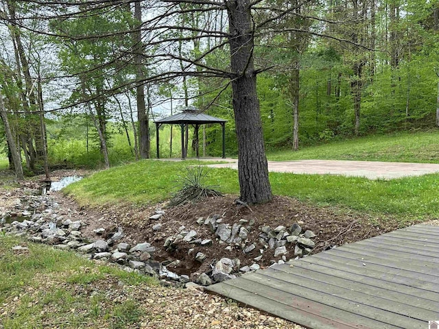 view of yard with a gazebo and a forest view