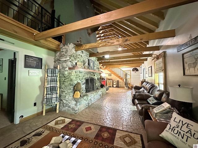 living room with beam ceiling, a fireplace, baseboards, and a high ceiling