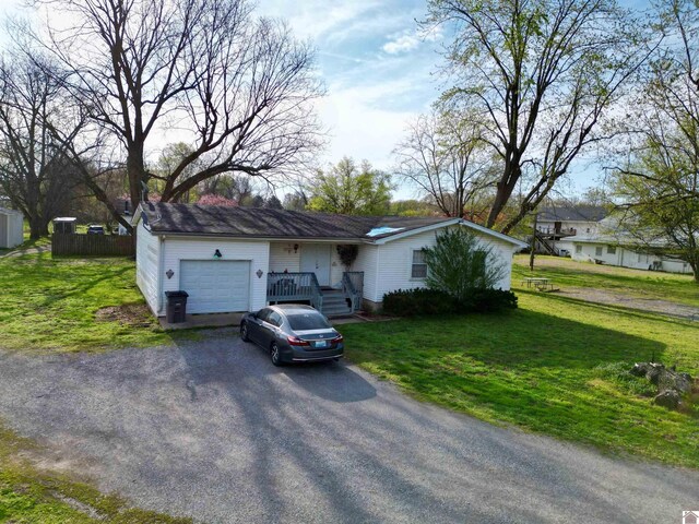 5770 Metropolis Lake Rd, West Paducah, KY 42086 - view of front of house with fence, an attached garage, driveway, and a front lawn