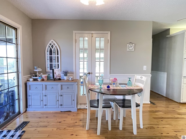 11189 E State Route 94, Murray, KY 42071 - dining room with a wainscoted wall, a textured ceiling, and light wood finished floors