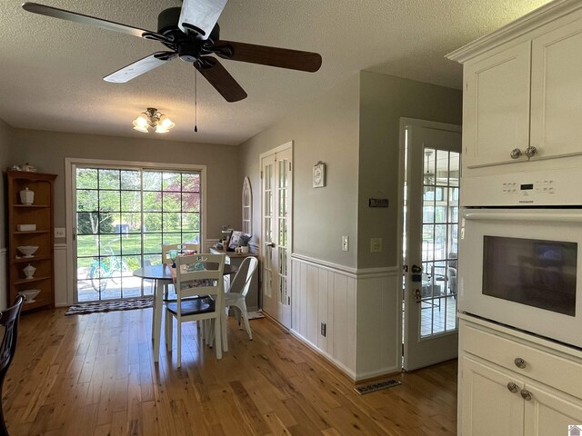 11189 E State Route 94, Murray, KY 42071 - dining room featuring a textured ceiling, light wood-style floors, and wainscoting