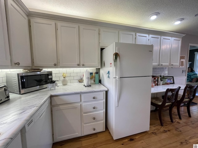 11189 E State Route 94, Murray, KY 42071 - kitchen featuring light wood-style floors, white appliances, a textured ceiling, and backsplash