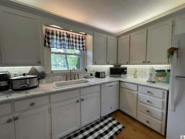 11189 E State Route 94, Murray, KY 42071 - kitchen featuring a sink, tasteful backsplash, white appliances, a textured ceiling, and wood finished floors
