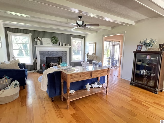 11189 E State Route 94, Murray, KY 42071 - living room featuring a textured ceiling, beamed ceiling, ceiling fan, light wood finished floors, and a fireplace