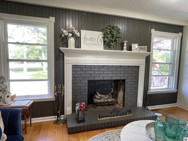 11189 E State Route 94, Murray, KY 42071 - living area with wood walls, visible vents, hardwood / wood-style floors, baseboards, and a fireplace