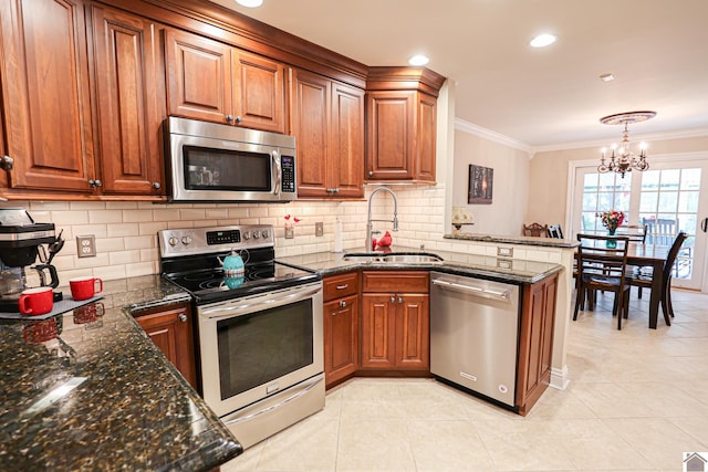 kitchen with an inviting chandelier, a sink, brown cabinets, stainless steel appliances, and light tile patterned floors