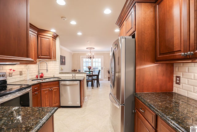 kitchen featuring an inviting chandelier, a sink, decorative backsplash, crown molding, and appliances with stainless steel finishes