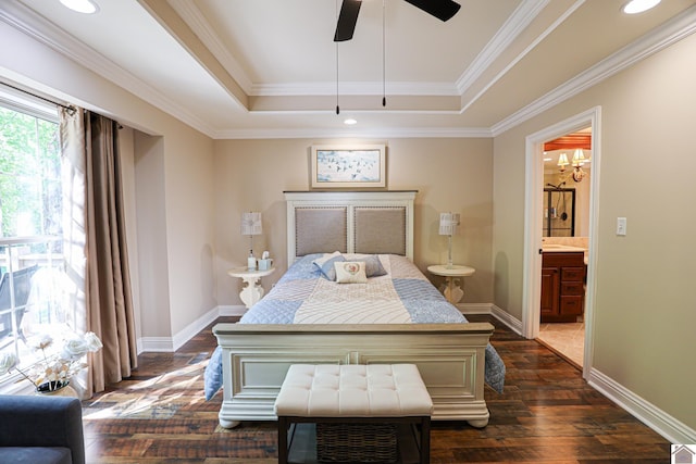 bedroom featuring dark wood-type flooring, ensuite bath, a raised ceiling, and baseboards
