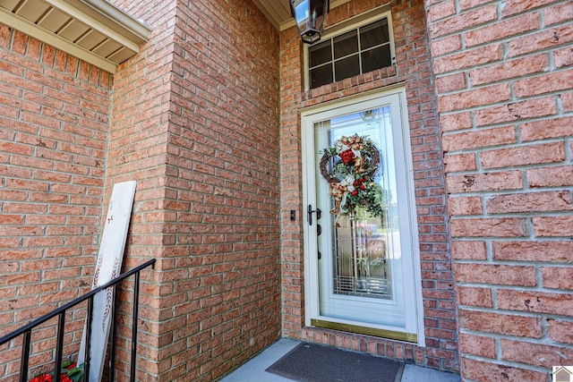 view of exterior entry featuring brick siding