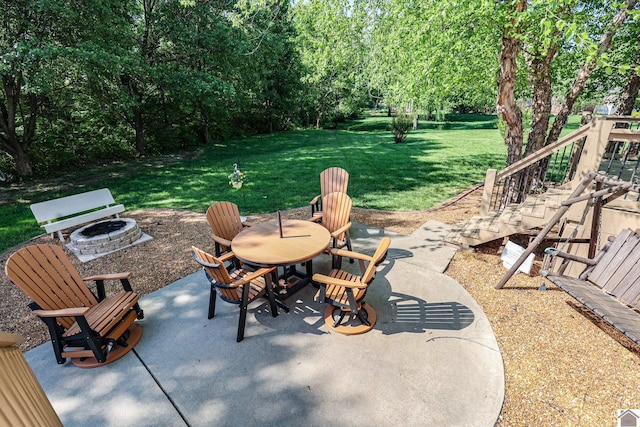 view of patio with an outdoor fire pit, outdoor dining area, and stairway
