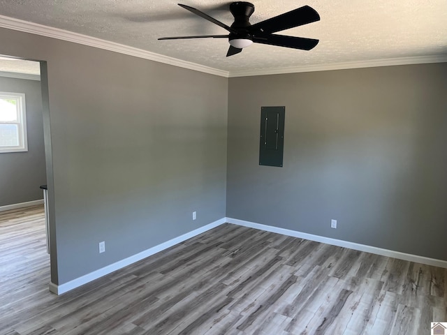 spare room featuring a textured ceiling, wood finished floors, ceiling fan, and electric panel