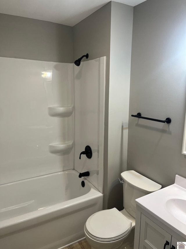 bathroom featuring toilet, vanity, and shower / bathing tub combination
