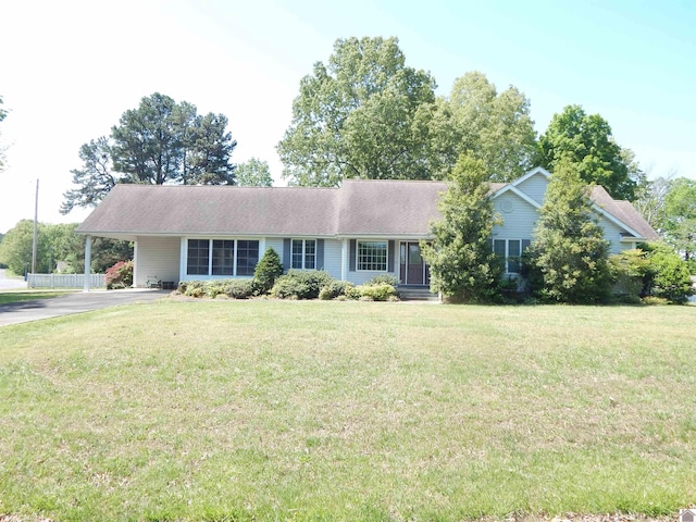 ranch-style home with driveway, a carport, and a front yard