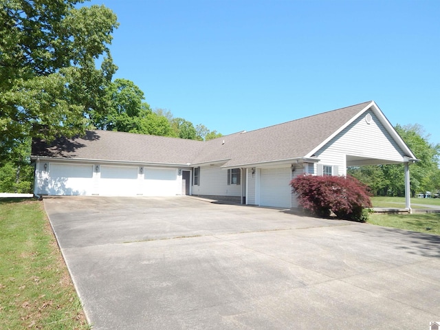 ranch-style house featuring driveway, a shingled roof, and an attached garage