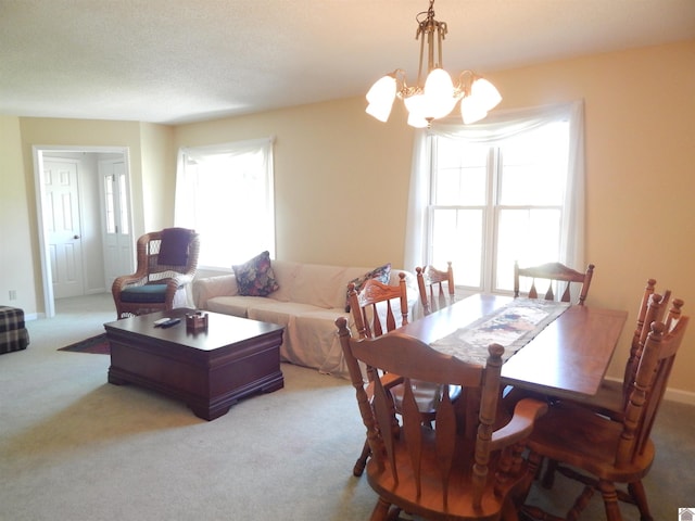 carpeted dining space featuring a notable chandelier